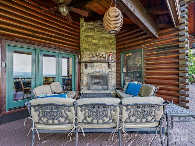 wooden terrace with ceiling fan and an outdoor living space with a fireplace