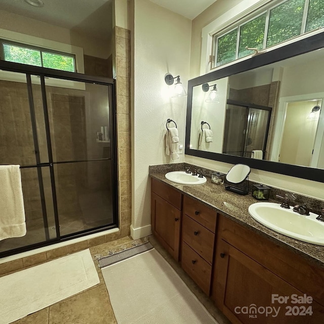 bathroom featuring vanity, walk in shower, and tile patterned flooring