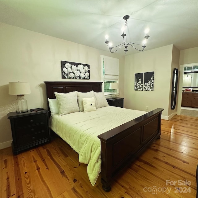 bedroom featuring wood-type flooring and a chandelier