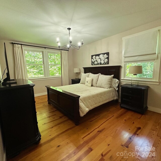 bedroom featuring a notable chandelier and hardwood / wood-style flooring