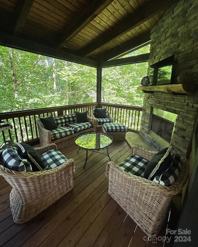 wooden terrace with an outdoor living space with a fireplace