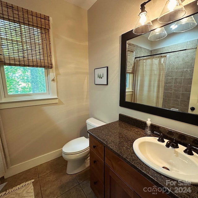 bathroom featuring tile patterned floors, a shower with shower curtain, toilet, and vanity