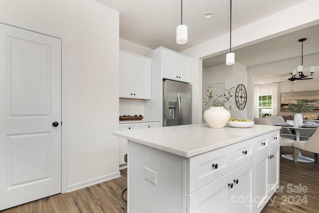 kitchen with hanging light fixtures, stainless steel fridge, white cabinets, wood-type flooring, and ceiling fan