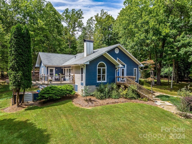 view of front of property featuring a front yard and a deck