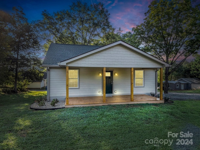 bungalow-style house with a yard and covered porch