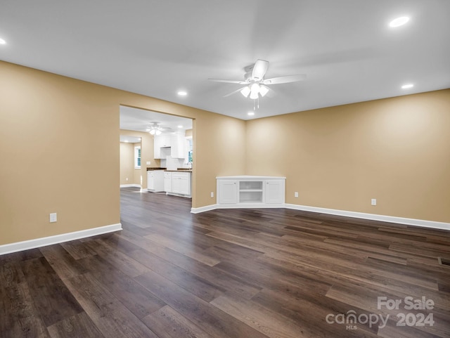 unfurnished living room with dark wood-type flooring and ceiling fan