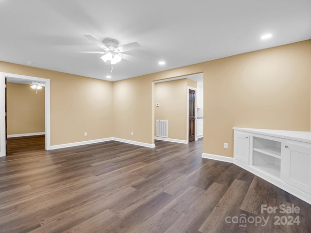 empty room featuring dark wood-type flooring and ceiling fan