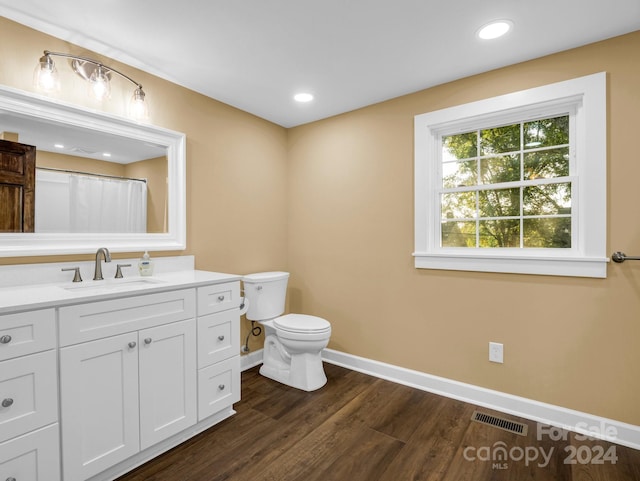 bathroom featuring vanity, toilet, and hardwood / wood-style flooring