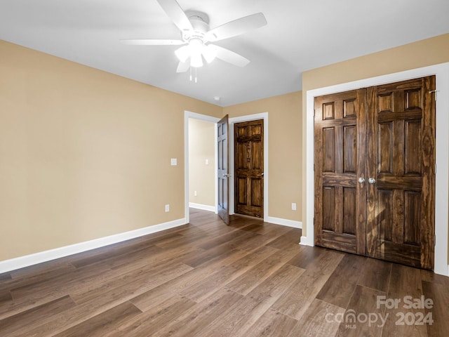 unfurnished bedroom with dark hardwood / wood-style flooring and ceiling fan