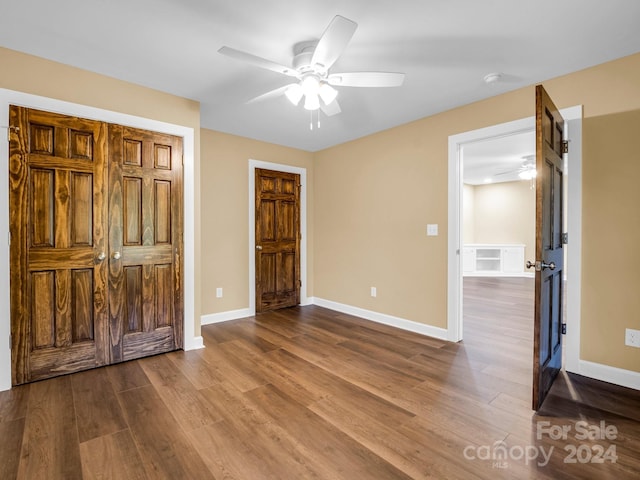 unfurnished bedroom with dark wood-type flooring and ceiling fan