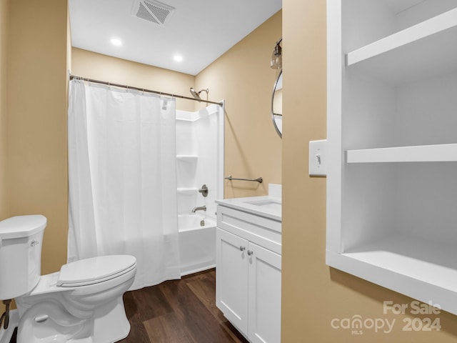 full bathroom with hardwood / wood-style floors, toilet, shower / bathtub combination with curtain, and vanity