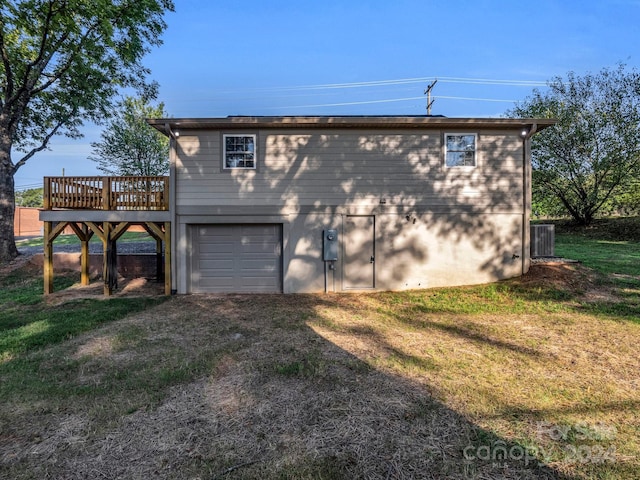 view of home's exterior with a lawn, a garage, a deck, and central AC unit