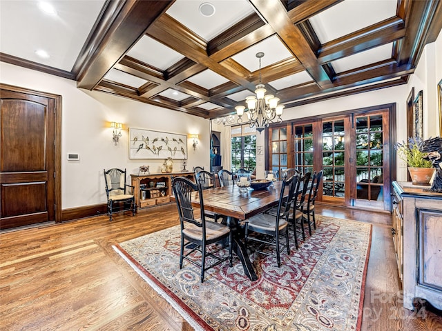 dining space featuring coffered ceiling, wood-type flooring, a notable chandelier, beamed ceiling, and crown molding