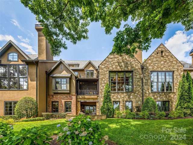 view of front of property with a front lawn and a balcony