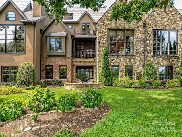 view of front of home with a front lawn and a balcony