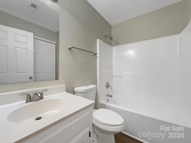 full bathroom featuring a textured ceiling, vanity, bathing tub / shower combination, and toilet