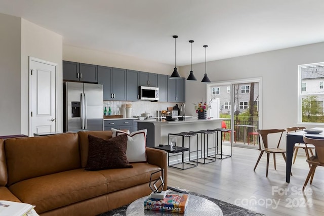 living room with sink and light hardwood / wood-style flooring