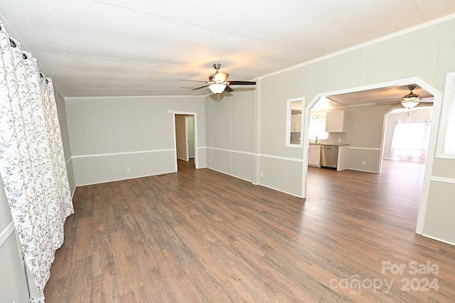 empty room featuring crown molding, a textured ceiling, a ceiling fan, and dark wood-style flooring