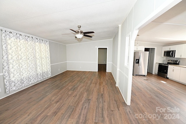 spare room with ornamental molding, dark wood-type flooring, and a ceiling fan