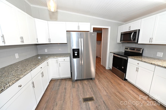 kitchen with crown molding, appliances with stainless steel finishes, vaulted ceiling, and wood finished floors