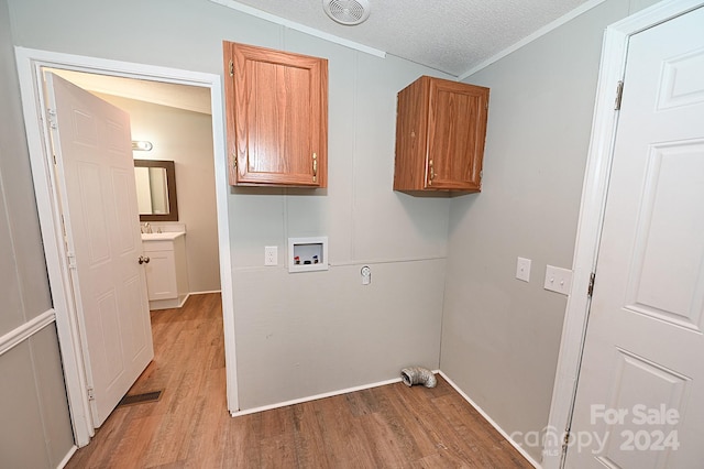 laundry room featuring cabinet space, visible vents, hookup for a washing machine, a textured ceiling, and light wood-type flooring