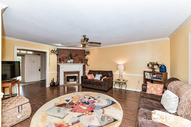 living room with crown molding, ceiling fan, dark wood-type flooring, and a brick fireplace