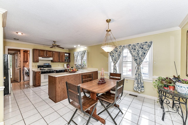 tiled dining area featuring a textured ceiling, crown molding, washer / clothes dryer, and ceiling fan