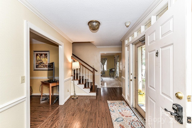 foyer entrance featuring a textured ceiling, crown molding, and dark wood-type flooring