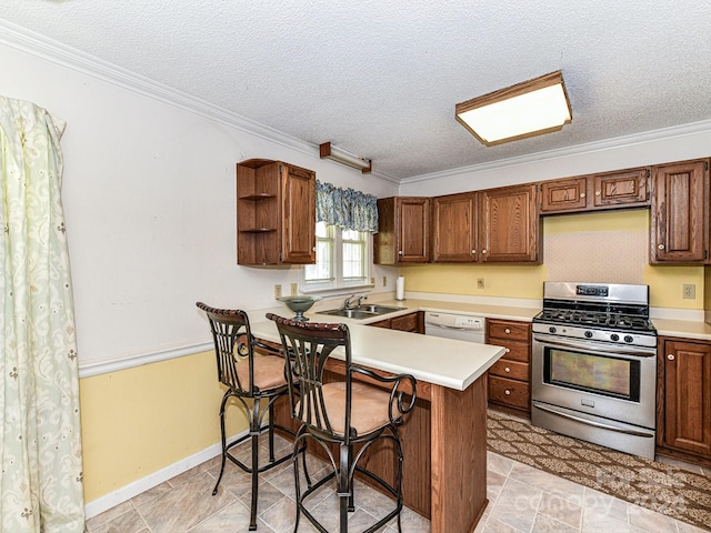 kitchen with stainless steel range with gas cooktop, kitchen peninsula, a kitchen breakfast bar, ornamental molding, and white dishwasher