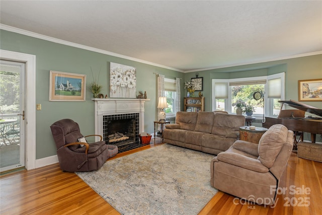 living room featuring hardwood / wood-style flooring, a fireplace, ornamental molding, and a wealth of natural light