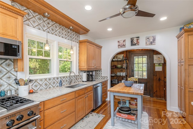 kitchen featuring stainless steel appliances, sink, wood counters, and light hardwood / wood-style flooring