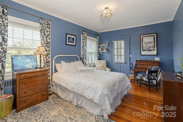 bedroom with ornamental molding and hardwood / wood-style floors