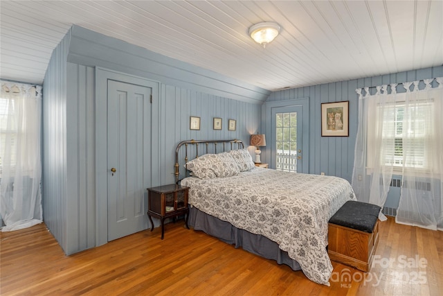 bedroom with multiple windows and hardwood / wood-style floors