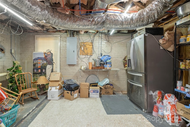 basement with stainless steel refrigerator with ice dispenser and electric panel