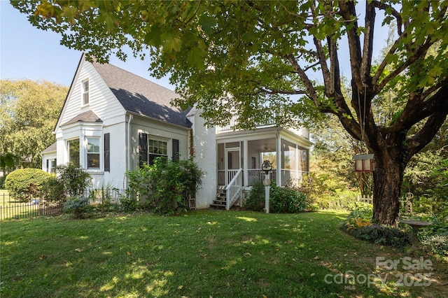 view of front of house with a sunroom and a front yard