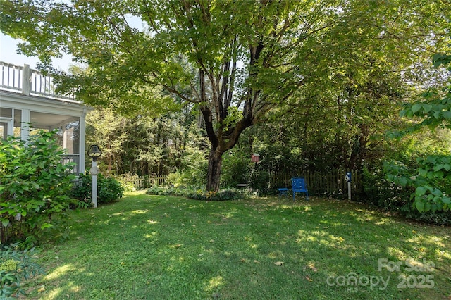 view of yard with a sunroom and a balcony