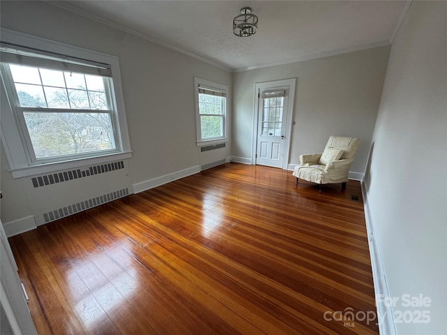 unfurnished room featuring dark wood-type flooring, ornamental molding, and radiator