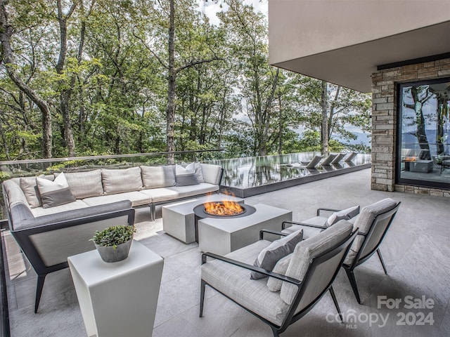 view of patio / terrace with an outdoor living space with a fire pit