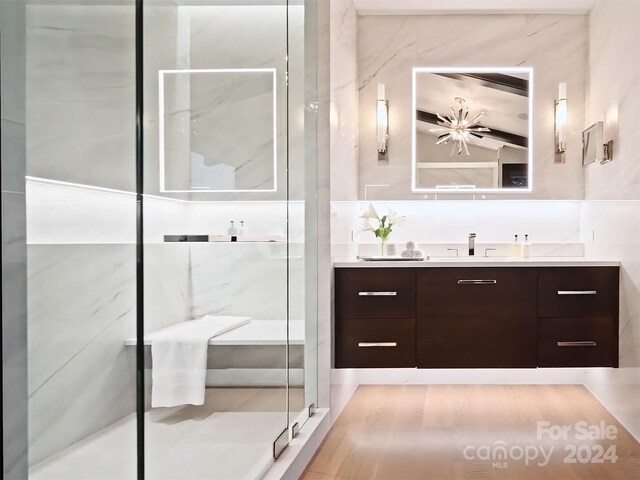 bathroom with vanity, hardwood / wood-style flooring, and a shower with shower door