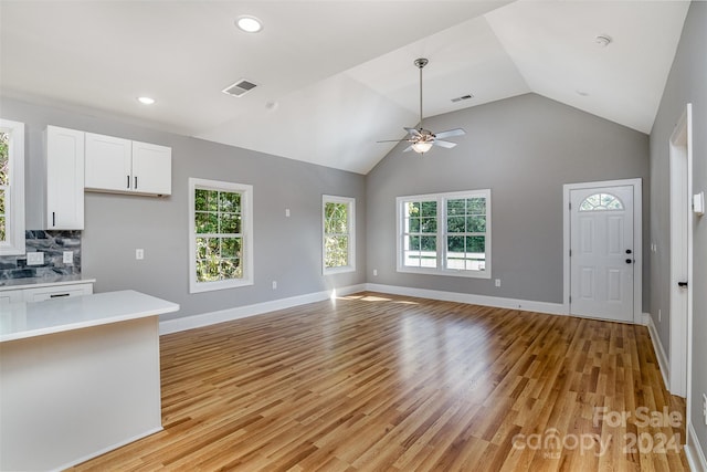 unfurnished living room with high vaulted ceiling, ceiling fan, and light hardwood / wood-style floors