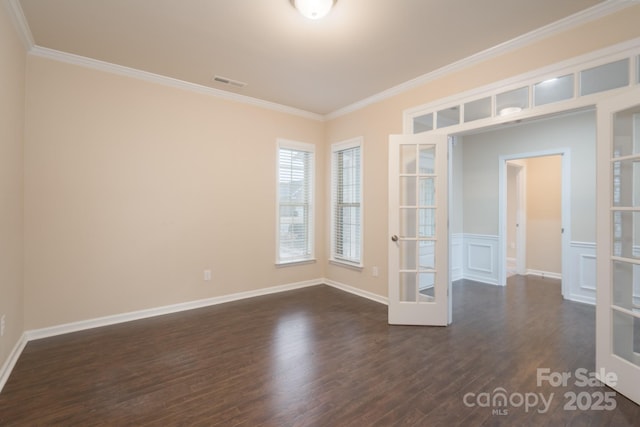 spare room featuring dark hardwood / wood-style floors, ornamental molding, and french doors