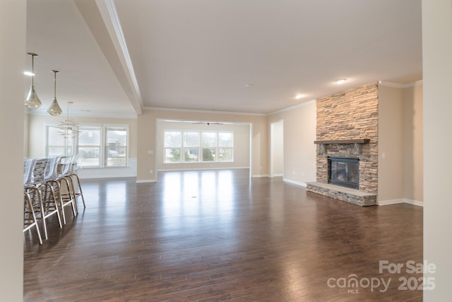 unfurnished living room featuring dark hardwood / wood-style flooring, a stone fireplace, and ornamental molding