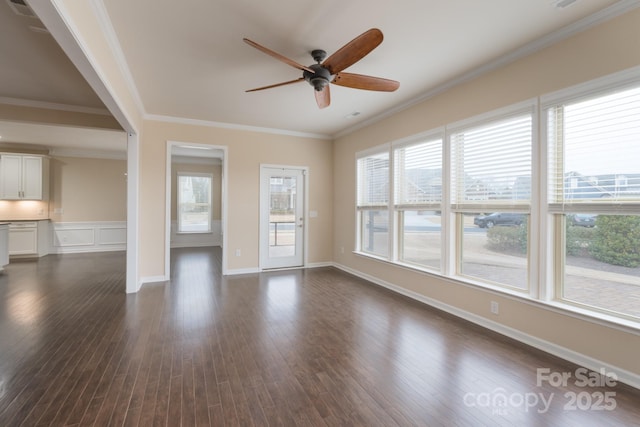 empty room featuring a wealth of natural light, ceiling fan, and crown molding