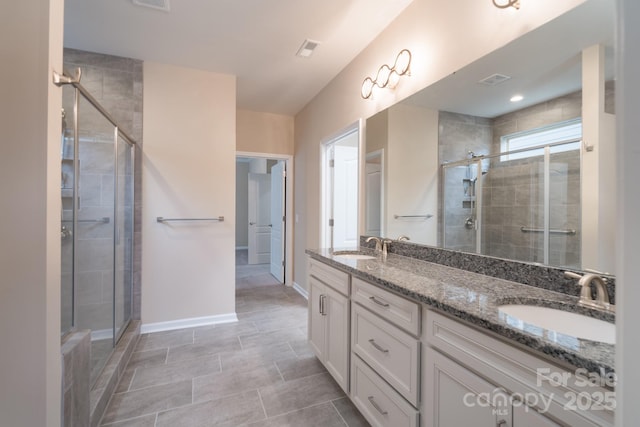 bathroom featuring tile patterned floors, a shower with door, and vanity