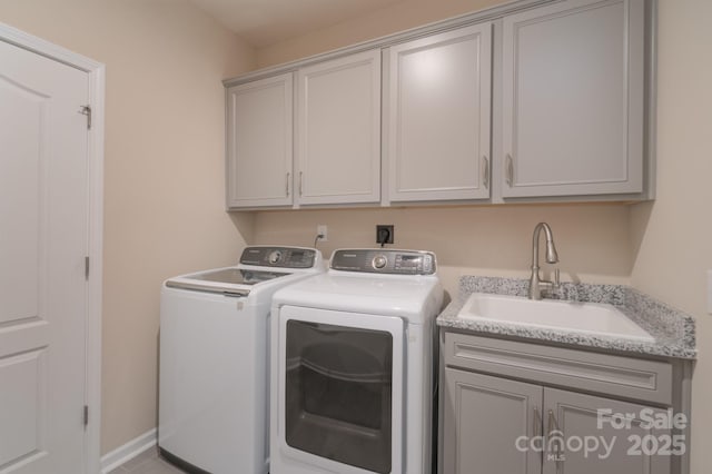 laundry room featuring cabinets, independent washer and dryer, and sink