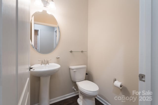 bathroom featuring wood-type flooring, toilet, and sink