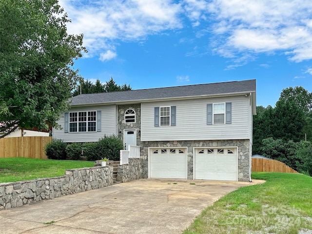 split foyer home featuring a front yard and a garage