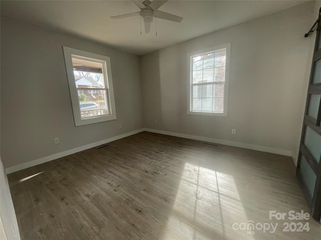 empty room featuring hardwood / wood-style flooring, ceiling fan, and a wealth of natural light