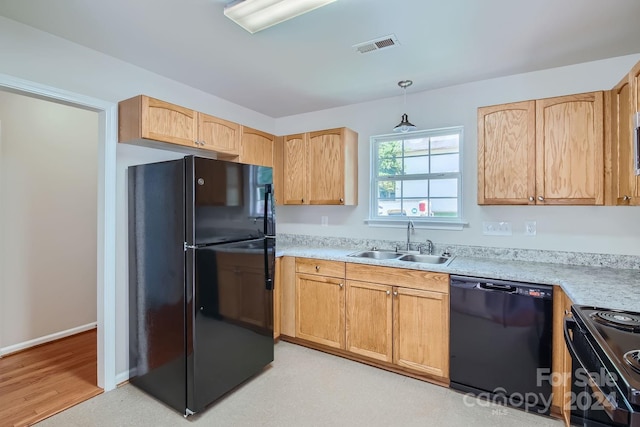 kitchen with a sink, visible vents, light countertops, light brown cabinetry, and black appliances