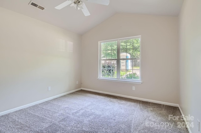 carpeted empty room featuring ceiling fan, baseboards, visible vents, and vaulted ceiling